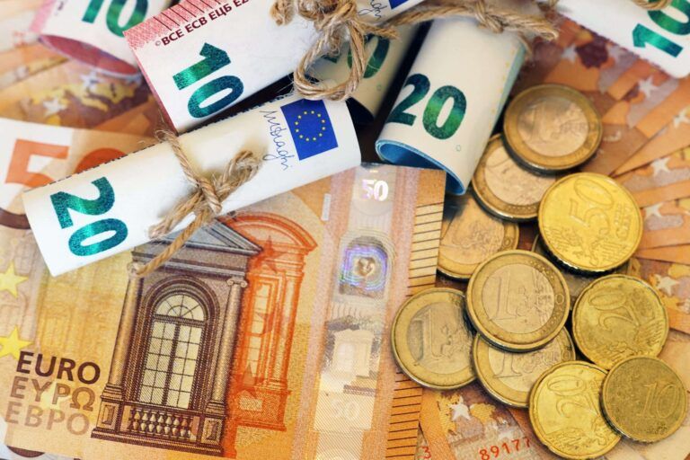 Euro-Banknoten und Münzen als Symbol für die Schadenregulierung