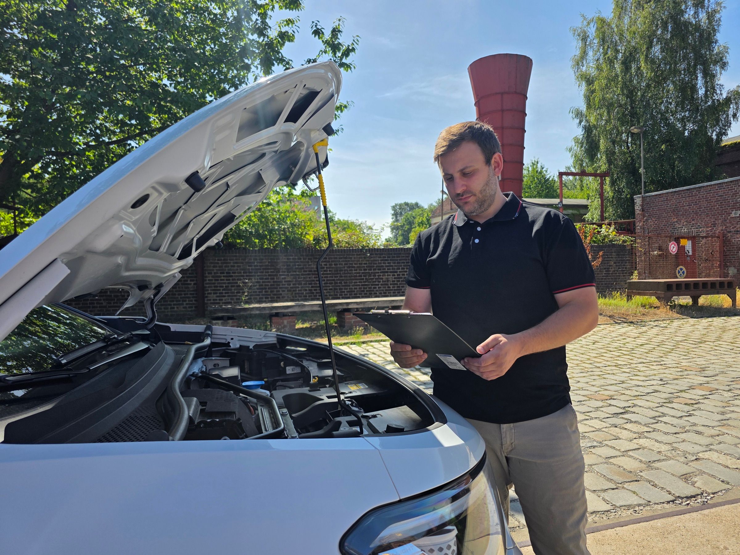 Kfz-Sachverständiger dokumentiert einen Fahrzeugschaden bei geöffneter Motorhaube